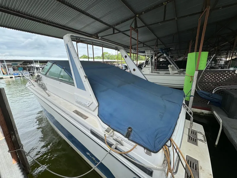 Slide: The Image of 1988 Sea Ray Sundancer 268 boat docked under a covered marina. - 3