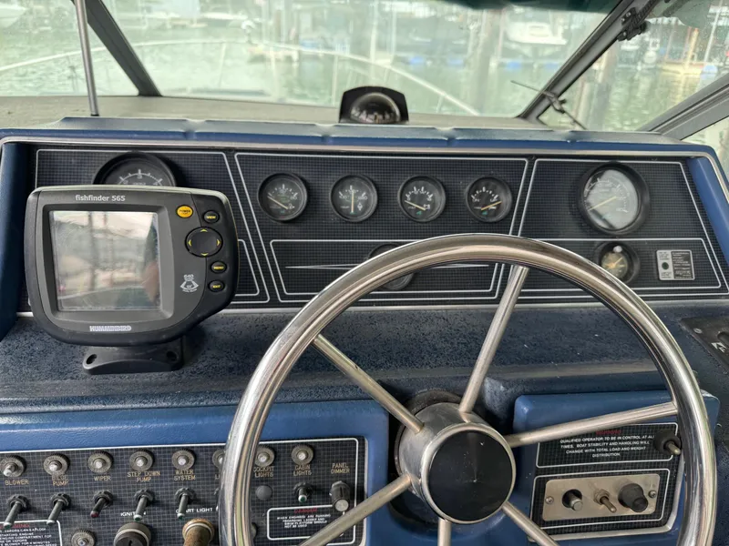 Slide: The Image of 1988 Sea Ray Sundancer 268 helm with steering wheel and navigation instruments. - 6