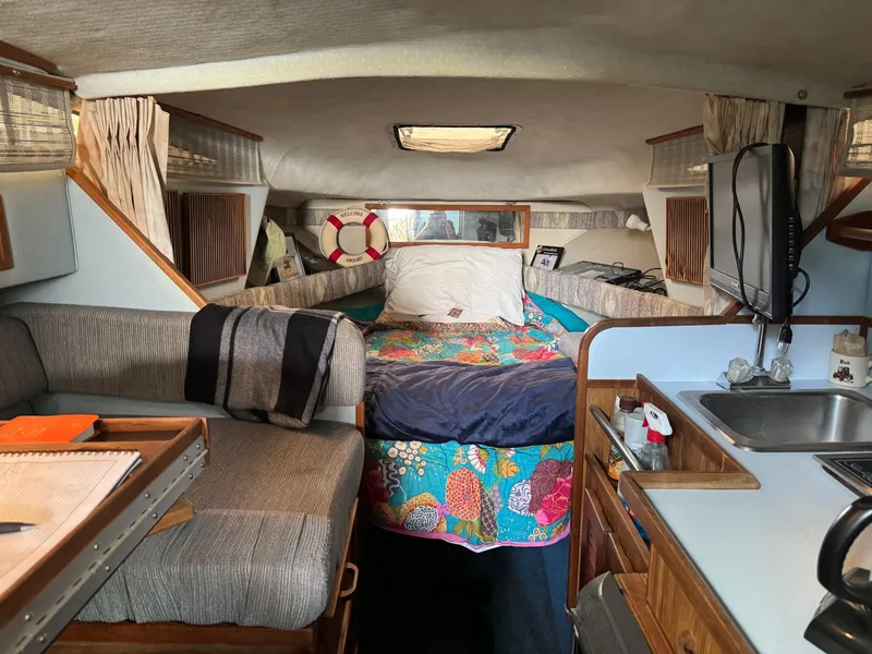 Slide: The Image of Interior of 1988 Sea Ray Sundancer 268 boat with cozy bed and kitchenette. - 8