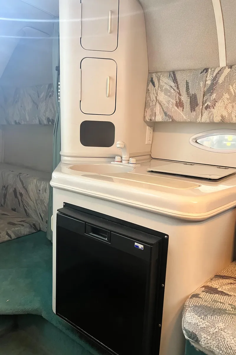 Slide: The Image of 1994 Chris-Craft 262 Crowne cabin interior with kitchenette and seating area. - 13