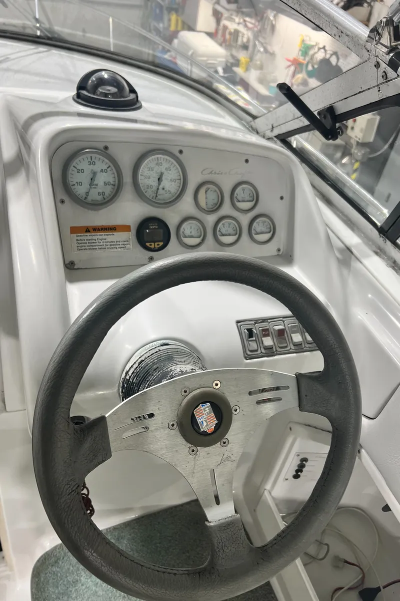 Slide: The Image of 1994 Chris-Craft 262 Crowne boat dashboard with steering wheel and gauges. - 6