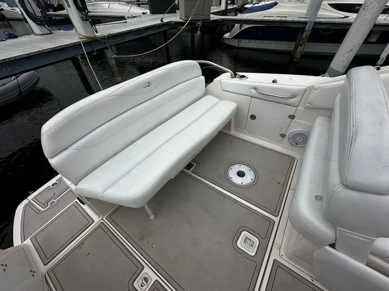 Slide: The Image of 2005 Regal Commodore 27 boat interior with white seating and docked at marina. - 14