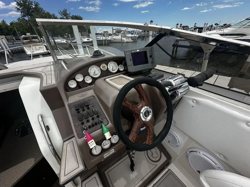 Slide: The Image of 2005 Regal Commodore 27 boat dashboard with steering wheel and control panel at marina. - 18