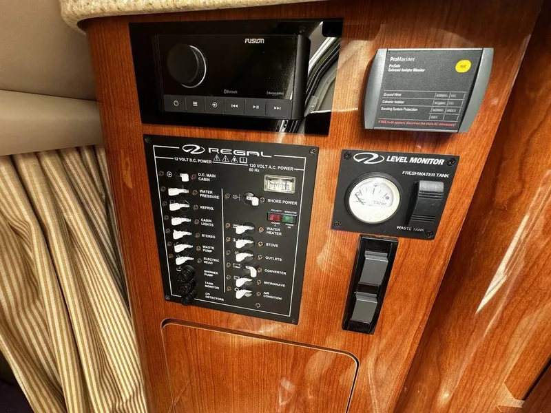 Slide: The Image of Control panel of a 2005 Regal Commodore 27 boat with various switches and monitors. - 20