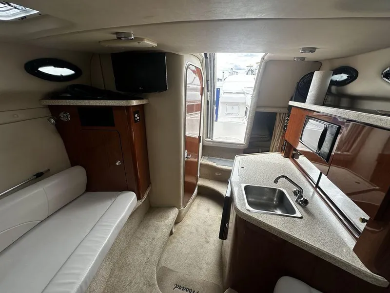 Slide: The Image of Interior of a 2005 Regal Commodore 27 boat with kitchenette and seating area. - 22