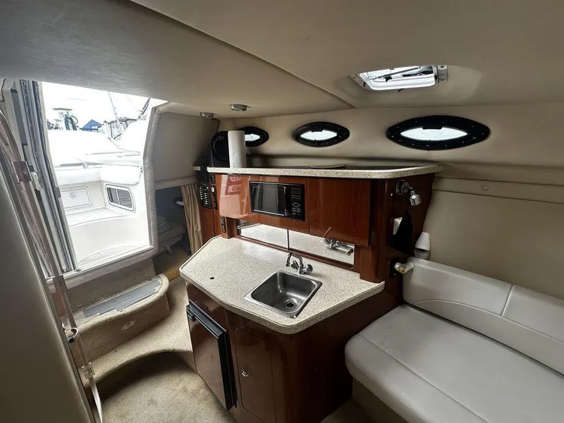 Slide: The Image of Interior of a 2005 Regal Commodore 27 boat with kitchenette and seating area. - 23