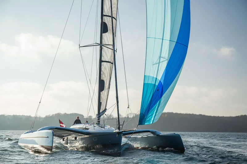 Slide: The Image of Sailing yacht Dragonfly 32, 2026 model, gliding on open water with blue sails. - 0
