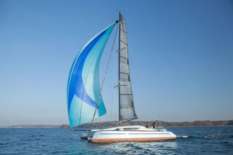Slide: The Image of Sailing catamaran Dragonfly 32, 2026 model, with blue sails on open water. - 3