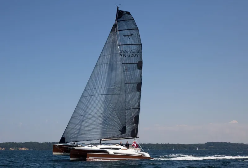 Slide: The Image of 2026 Dragonfly 32 sailboat gliding on open water under clear blue skies. - 5