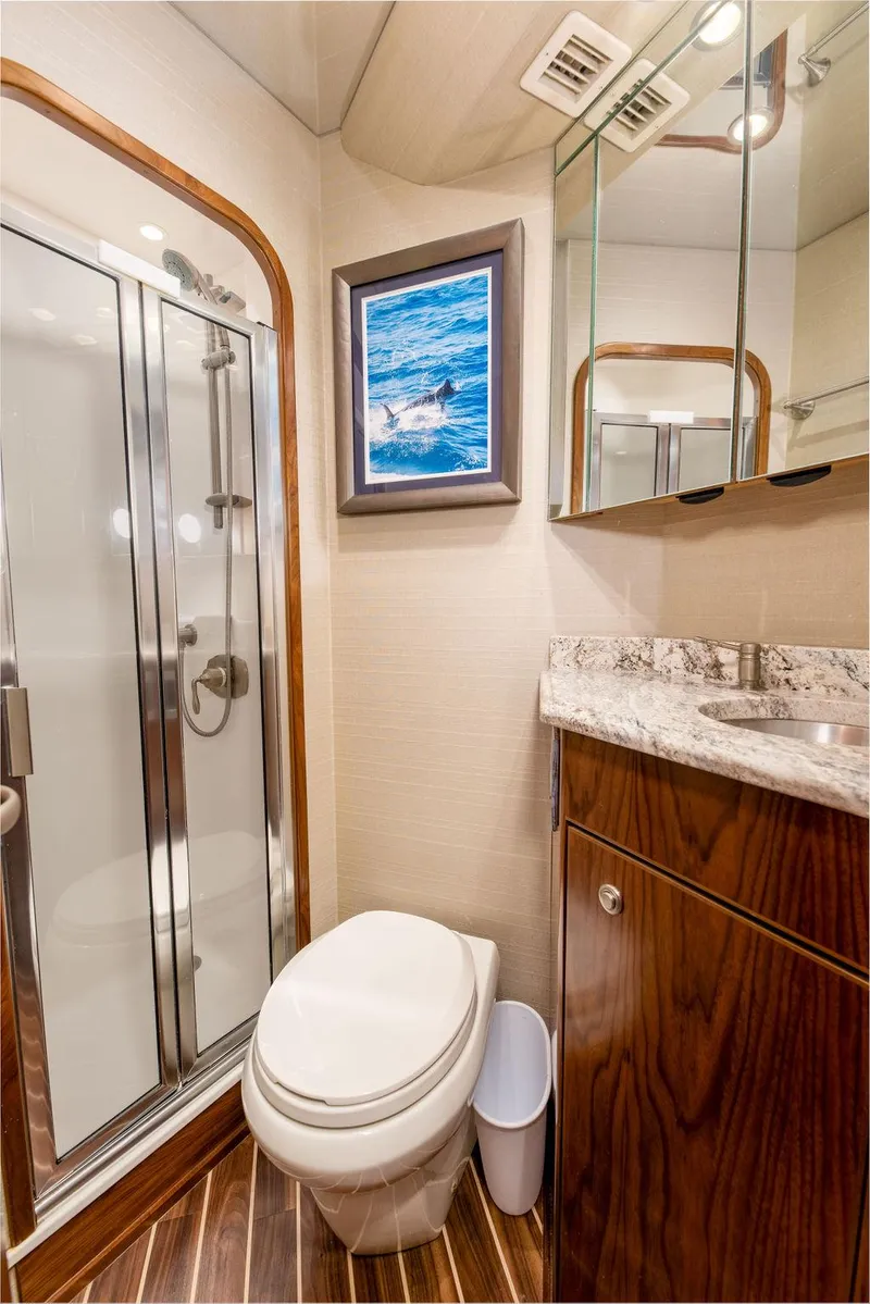 Slide: The Image of 2017 Viking 72 Convertible yacht bathroom with shower, toilet, and mirrored cabinet. - 36
