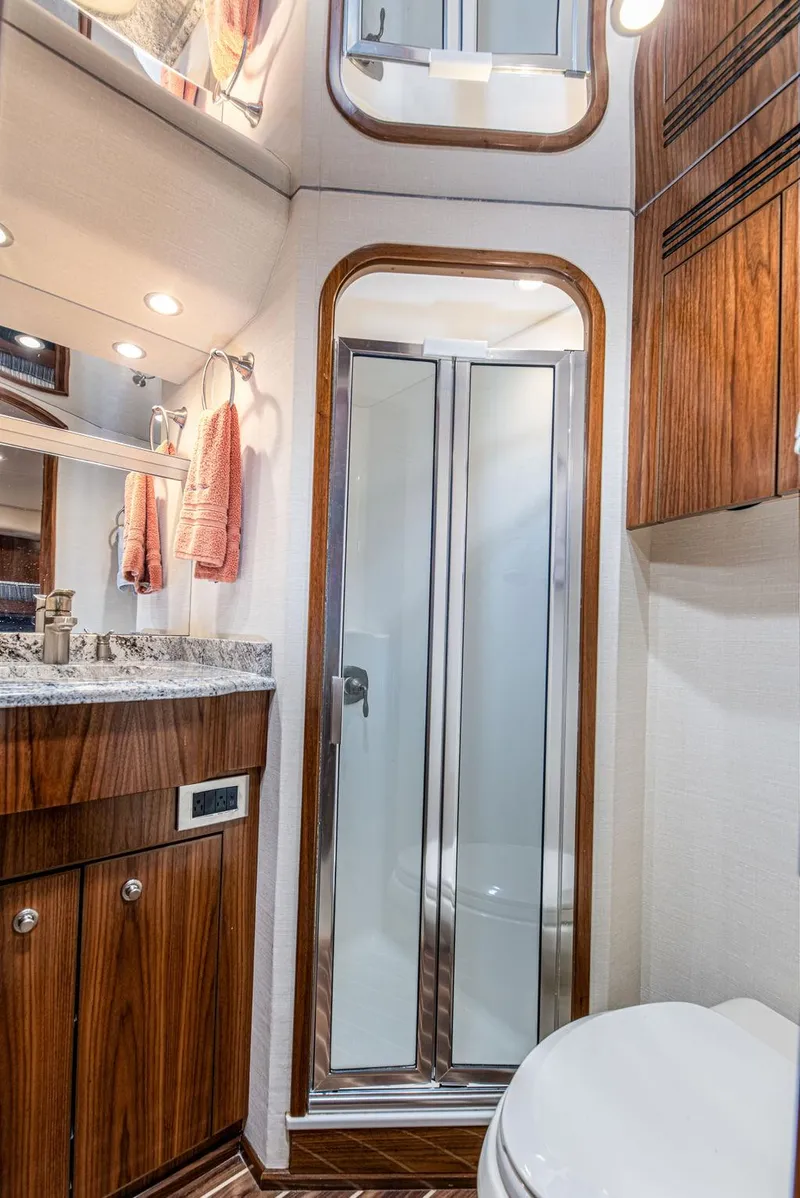Slide: The Image of 2017 Viking 72 Convertible yacht bathroom with wood cabinetry and glass shower. - 40