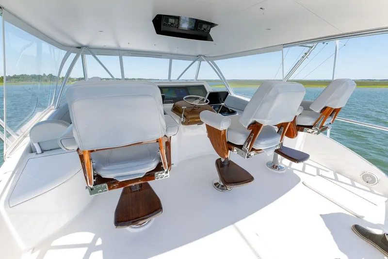 Slide: The Image of 2017 Viking 72 Convertible yacht helm station with white captain chairs. - 8