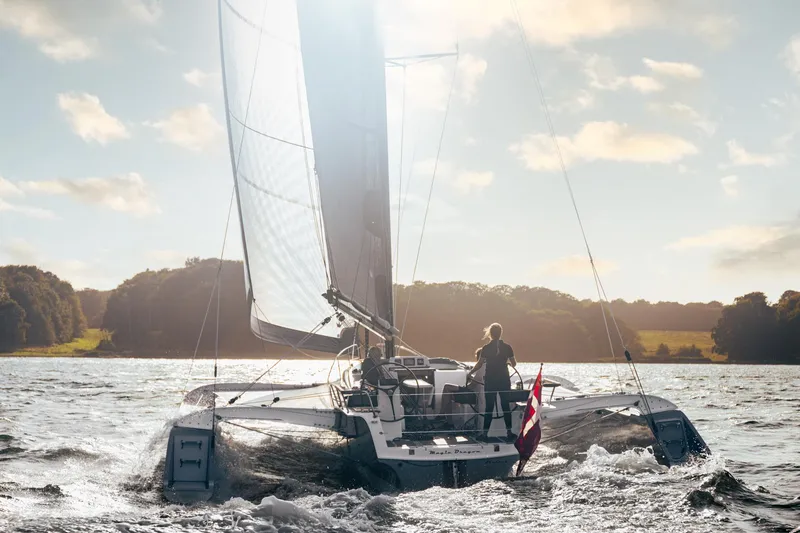 Slide: The Image of Sailing on a Dragonfly 40 trimaran, 2026 model, in a scenic lake setting. - 3