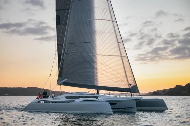 Slide: The Image of 2026 Dragonfly 40 sailboat on calm water at sunset. - 6