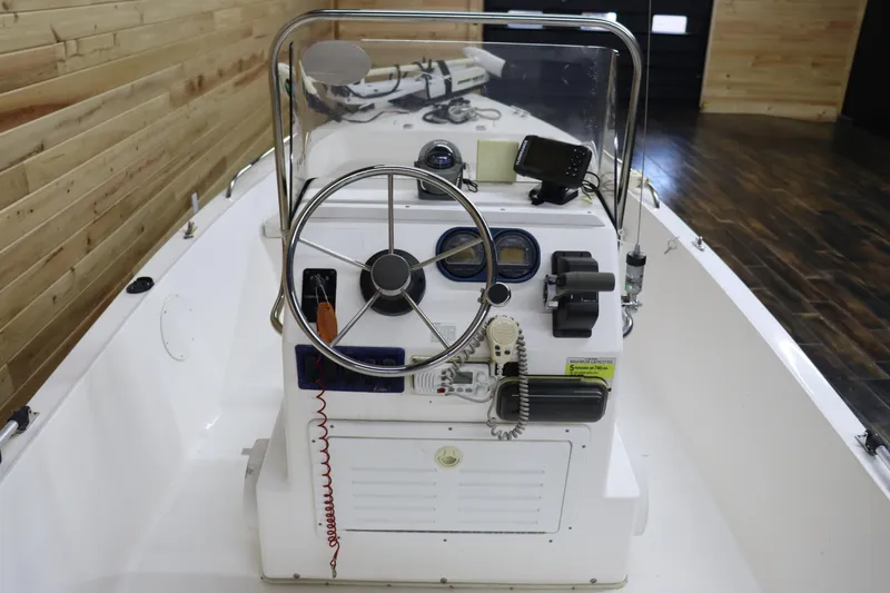 Slide: The Image of 2002 Cobia 174 Center Console boat interior with steering wheel and control panel. - 13