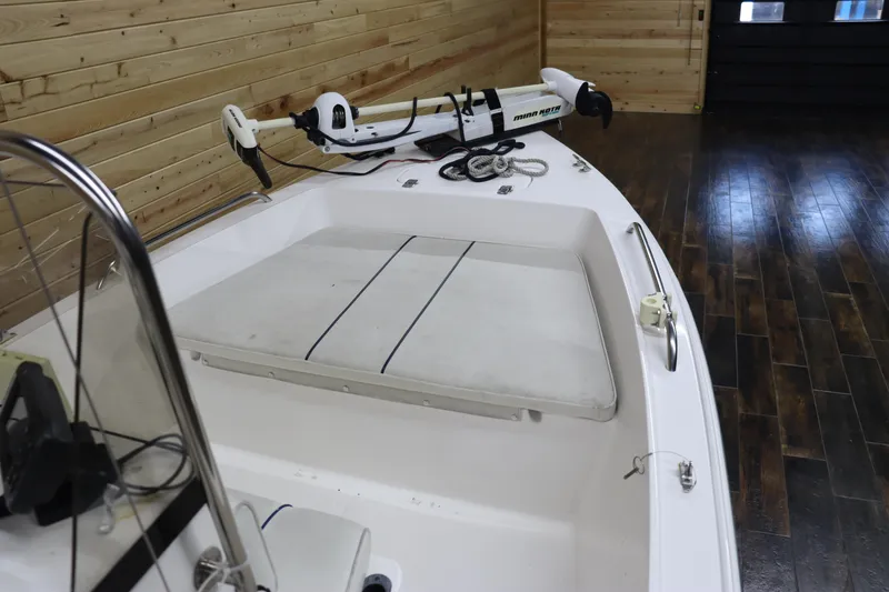 Slide: The Image of 2002 Cobia 174 Center Console boat with Minn Kota trolling motor in wooden garage. - 14