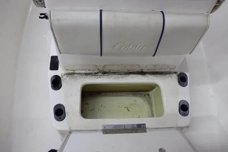 Slide: The Image of 2002 Cobia 174 Center Console boat seat with storage compartment and rod holders. - 15