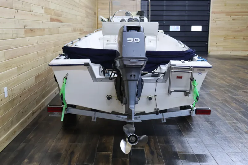 Slide: The Image of 2002 Cobia 174 Center Console boat with 90 HP outboard motor in indoor storage. - 4