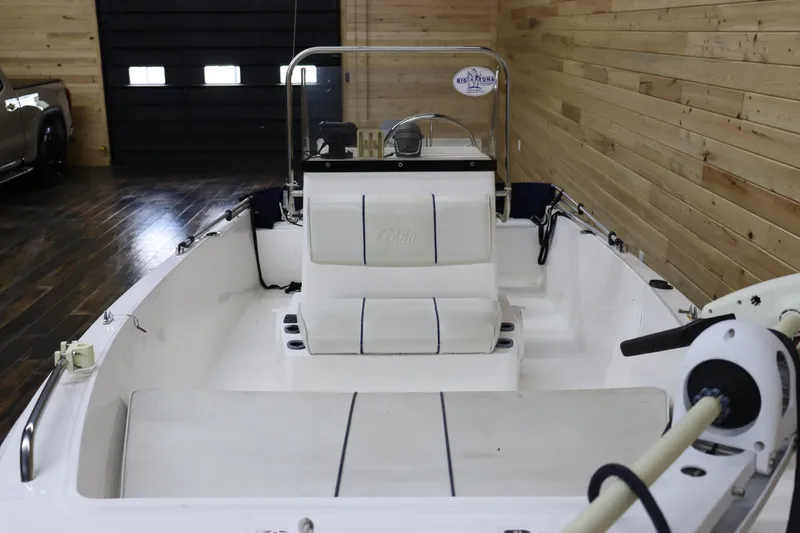 Slide: The Image of 2002 Cobia 174 Center Console boat interior with white seating and wooden walls. - 9