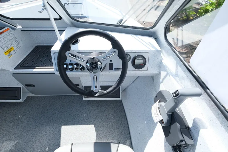 Slide: The Image of 2024 KingFisher 1825 Falcon boat cockpit with steering wheel and control panel. - 13