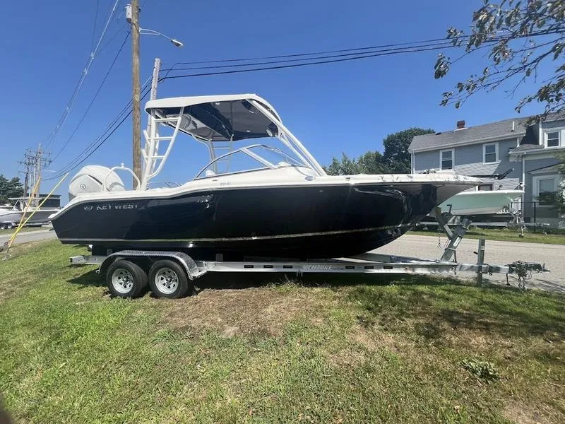 The Image of 2025 Key West 239 DFS boat on trailer, parked on grass. - 1