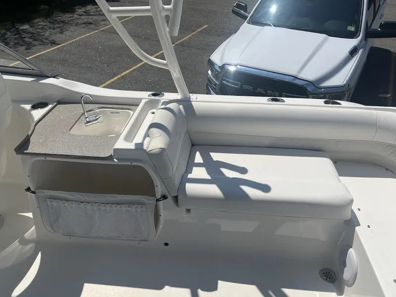 Slide: The Image of 2025 Key West 239 DFS boat interior with seating and sink, parked near a white truck. - 6