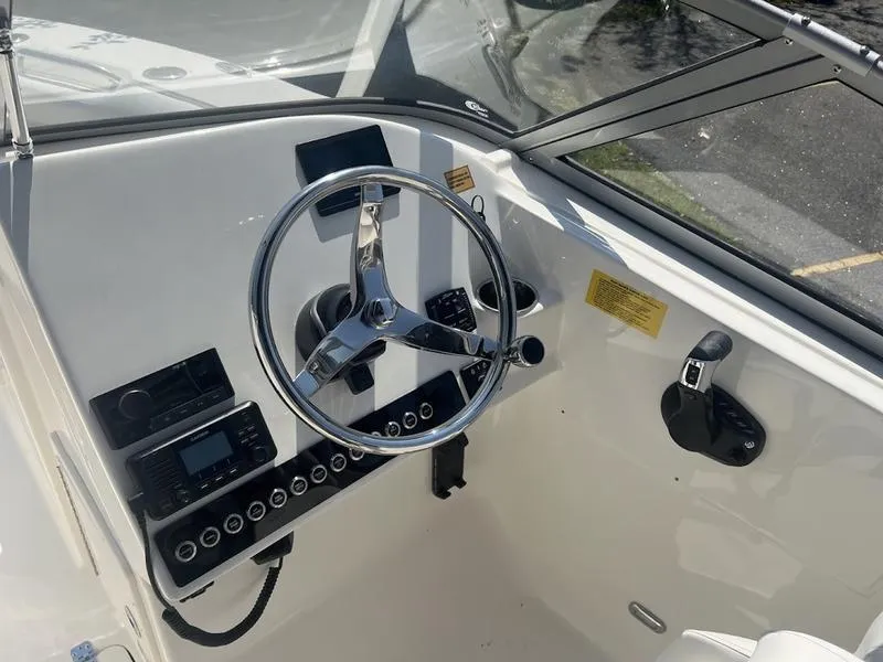 Slide: The Image of 2025 Key West 239 DFS boat dashboard with steering wheel and controls. - 9