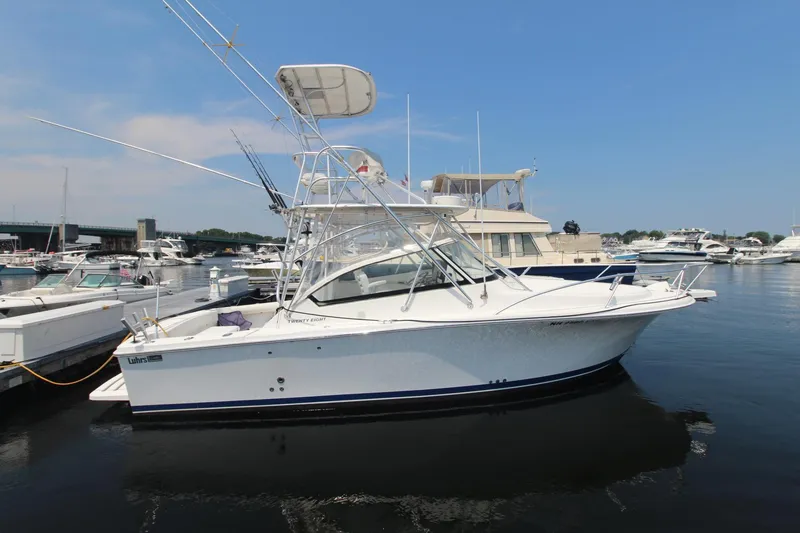 Slide: The Image of 2007 Luhrs 28 Open boat docked in a marina, clear sky background. - 0