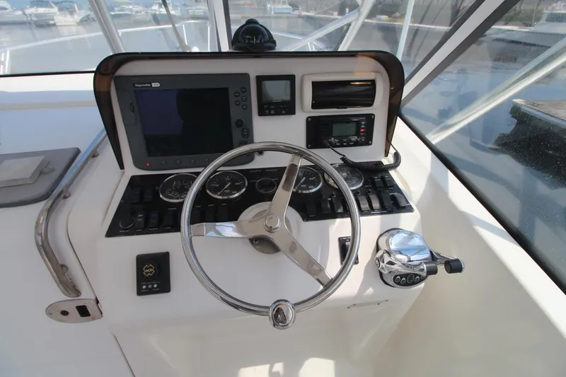 Slide: The Image of 2007 Luhrs 28 Open helm with steering wheel, gauges, and navigation equipment. - 11