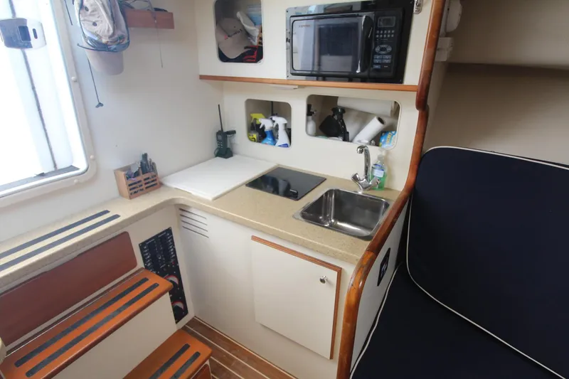 Slide: The Image of Compact kitchen area in a 2007 Luhrs 28 Open boat with sink and microwave. - 18