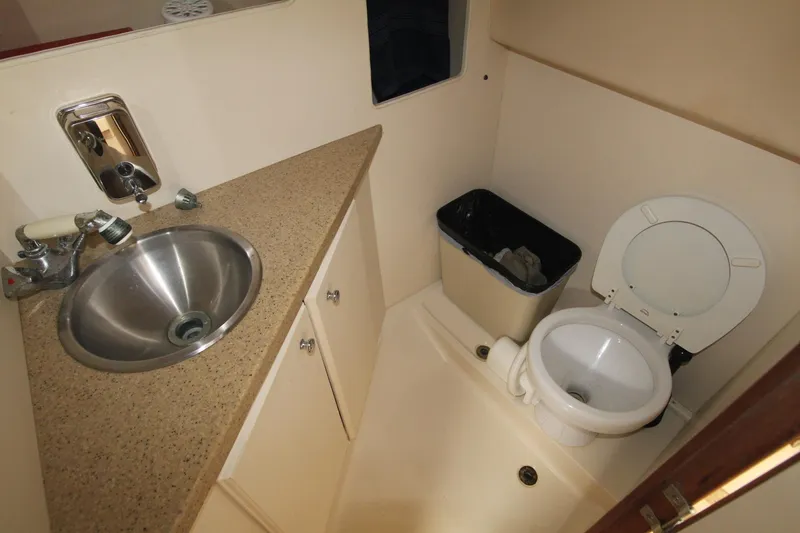 Slide: The Image of 2007 Luhrs 28 Open boat bathroom with sink, toilet, and trash bin. - 22