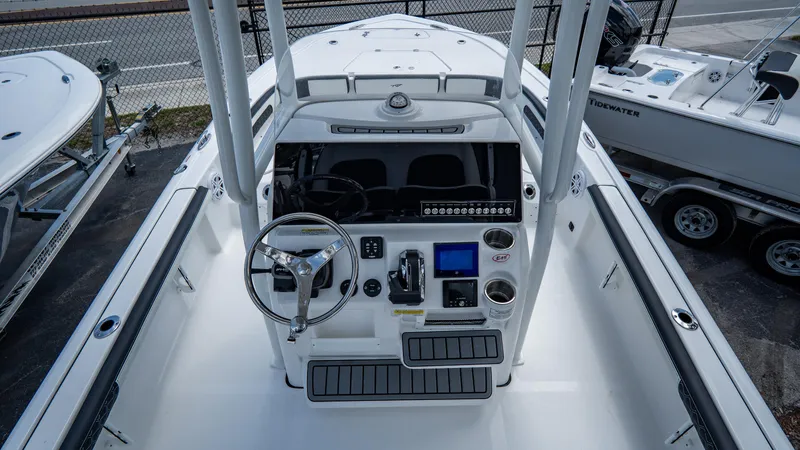 Slide: The Image of 2025 Tidewater 2300 Carolina Bay boat console with steering wheel and navigation controls. - 10