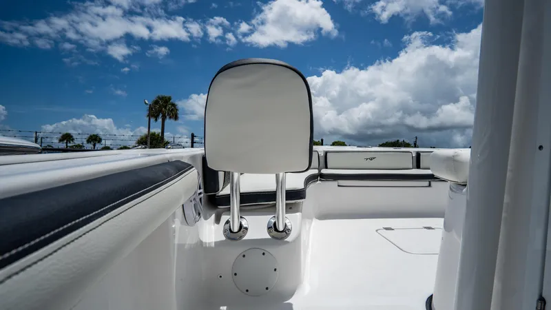 Slide: The Image of 2025 Tidewater 2300 Carolina Bay boat interior with white seating and blue sky. - 18