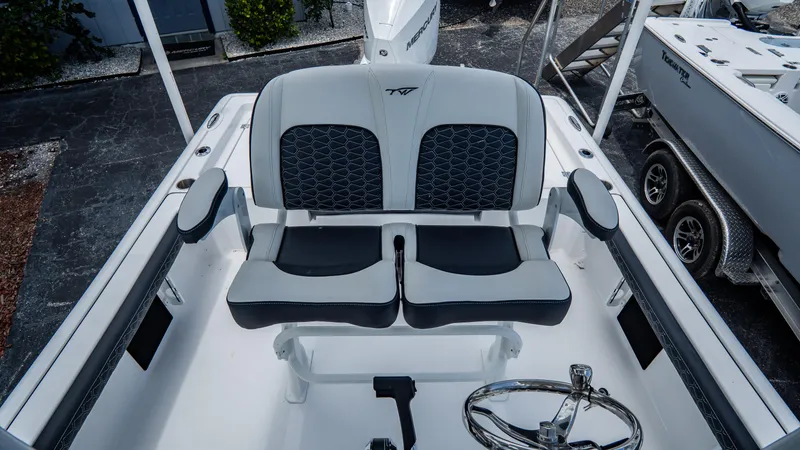 Slide: The Image of 2025 Tidewater 2300 Carolina Bay boat interior with dual seating and steering wheel. - 9