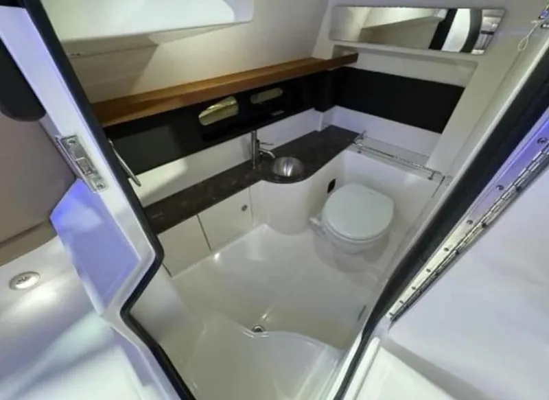Slide: The Image of 2018 Sea Ray SLX 350 OB boat bathroom with sink, toilet, and storage cabinets. - 14