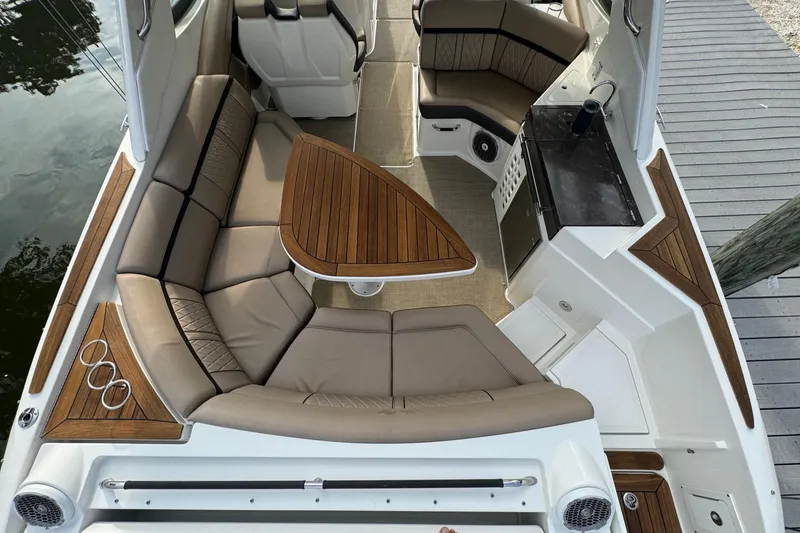 Slide: The Image of 2018 Sea Ray SLX 350 OB boat interior with luxurious seating and wooden table. - 21