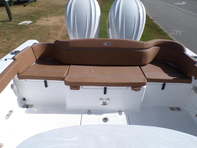Slide: The Image of 2025 Sea Hunt Ultra 305 SE boat with brown cushioned seating and twin outboard motors. - 17