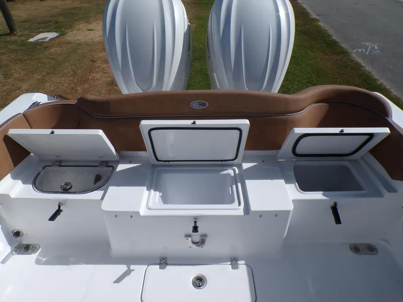 Slide: The Image of 2025 Sea Hunt Ultra 305 SE boat with open storage compartments and twin engines. - 18