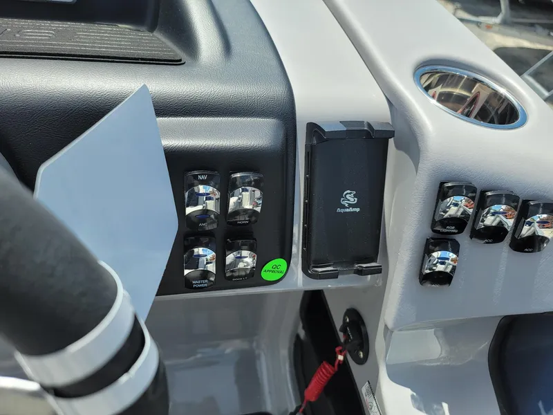 Slide: The Image of Control panel of 2025 Harris Cruiser 210 boat with switches and cup holder. - 16