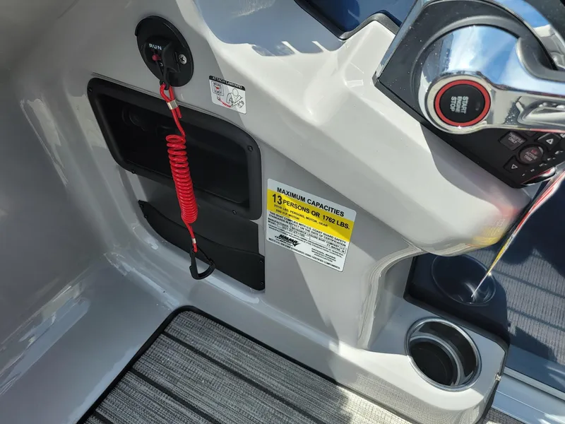 Slide: The Image of 2025 Harris Cruiser 210 boat control panel with safety features and capacity label. - 17