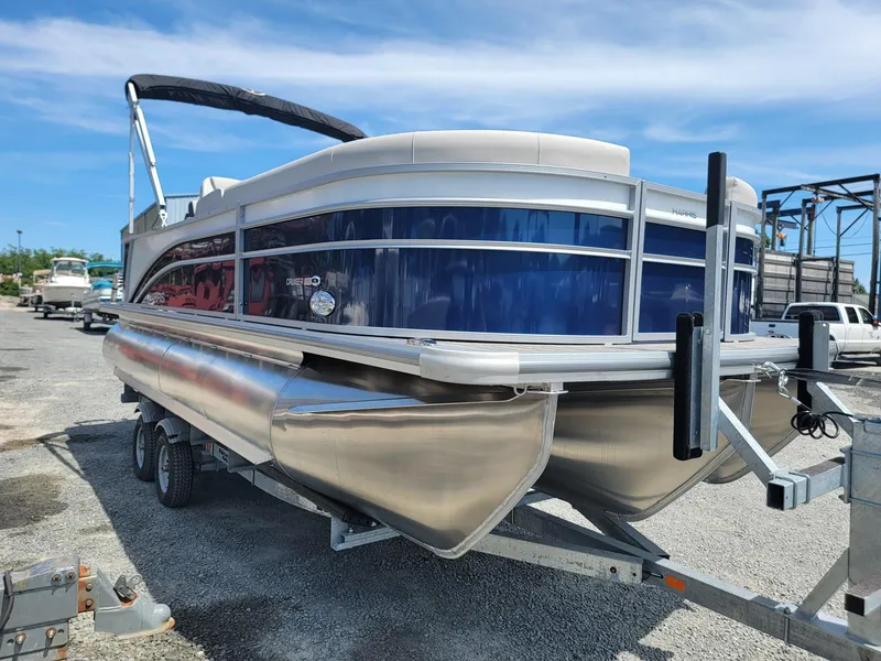 Slide: The Image of 2025 Harris Cruiser 210 pontoon boat on a trailer, blue and white exterior. - 6