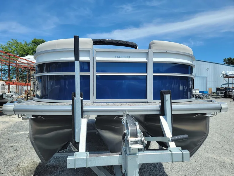 Slide: The Image of 2025 Harris Cruiser 210 pontoon boat on a trailer, blue and white exterior. - 7