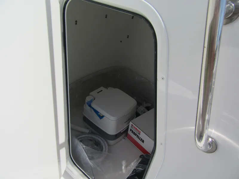 Slide: The Image of Storage compartment of Parker 2300 SE CC boat, featuring a portable toilet and propeller box. - 6