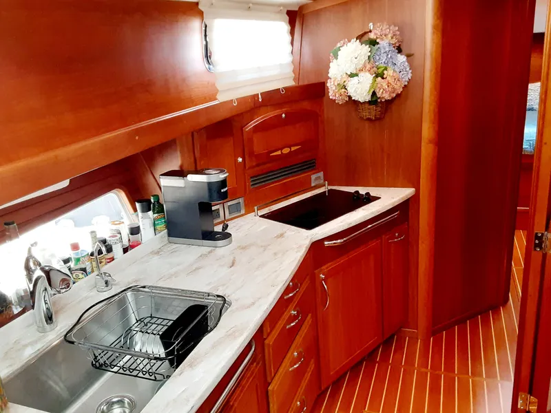 Slide: The Image of 2016 Sabre 48 Salon Express kitchen with modern appliances and wooden cabinetry. - 19