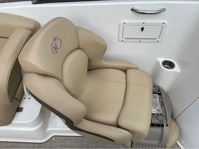 Slide: The Image of 2020 NauticStar 243 DC beige captain's chair with armrests and cup holder. - 10
