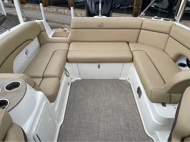 Slide: The Image of 2020 NauticStar 243 DC boat interior with beige seating and cup holders. - 14