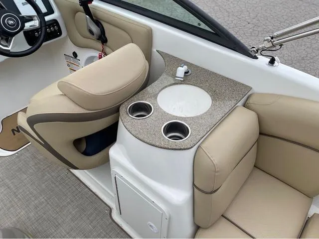 Slide: The Image of 2020 NauticStar 243 DC boat interior with beige seating and cup holders. - 15