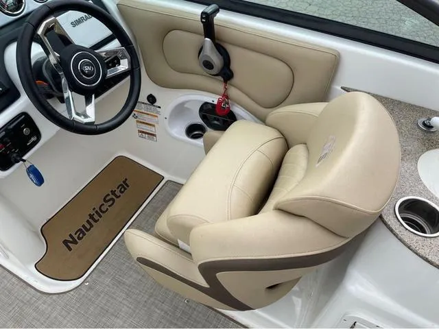Slide: The Image of 2020 NauticStar 243 DC boat interior with steering wheel and beige captain's chair. - 9