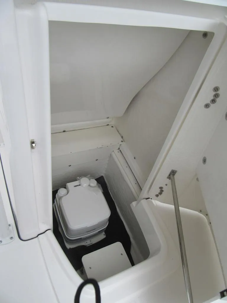 Slide: The Image of 2025 Robalo R200 Center Console boat storage compartment with portable toilet. - 10