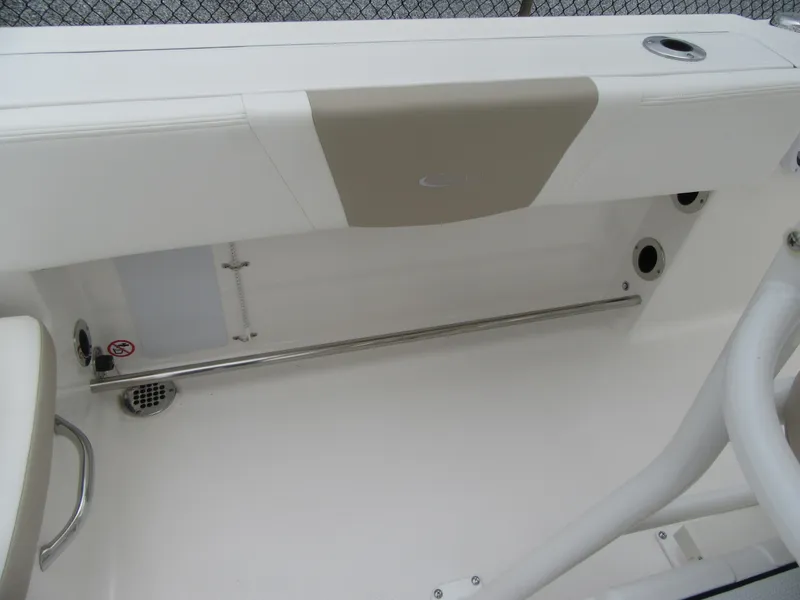 Slide: The Image of 2025 Robalo R200 Center Console boat interior detail with storage compartment and stainless steel railing. - 13
